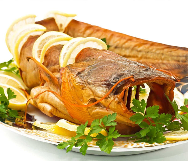 Baked Catfish with Lemonslices and Herbs on a Plate
